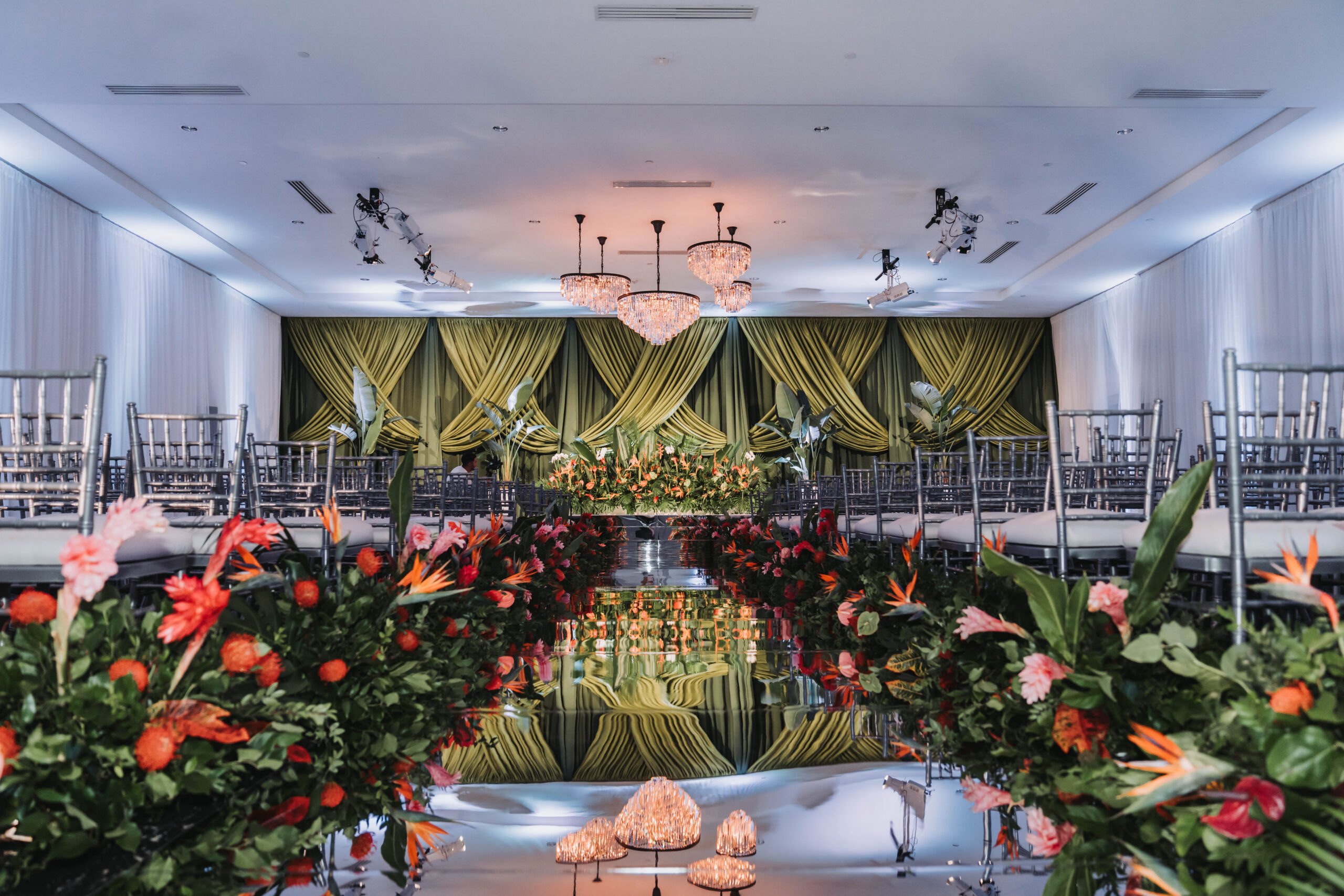 Reflective wedding aisle with floral arrangements